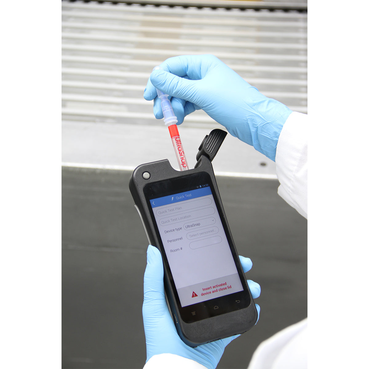Close-up of gloved hands inserting an UltraSnap ATP swab into a Hygiena EnSURE Touch luminometer